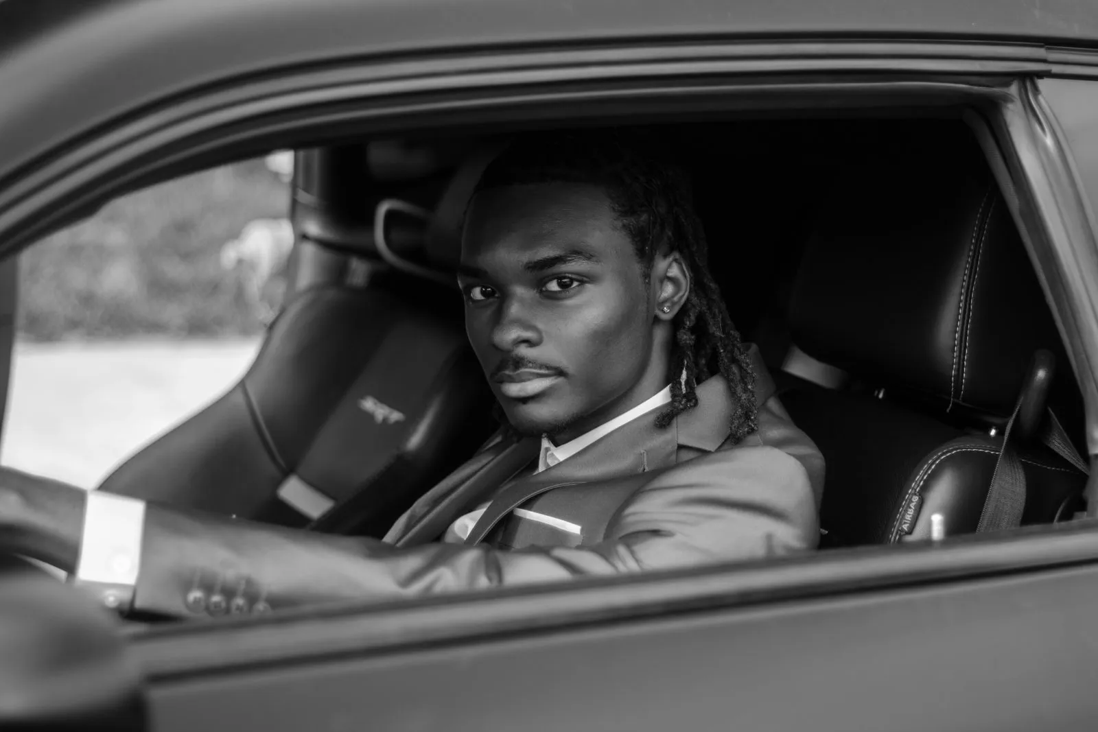 Young man posed in the driver seat of a car