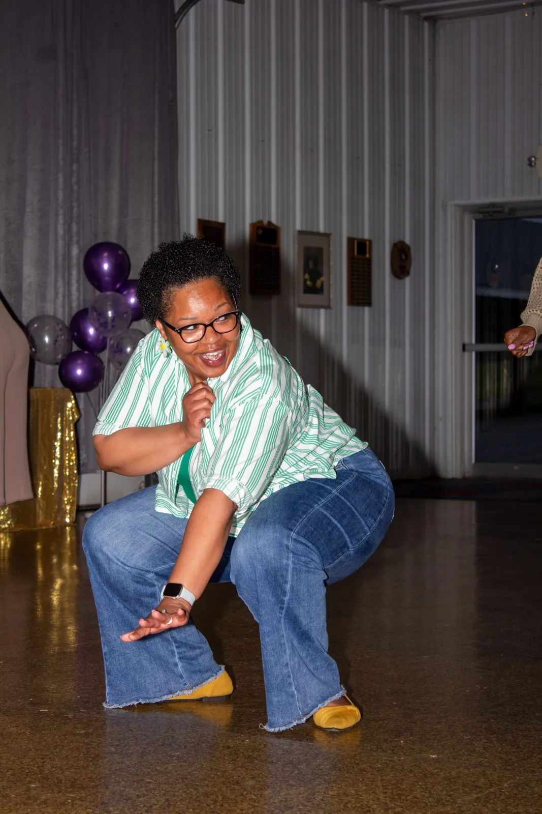Guest dancing at a celebration with purple balloons