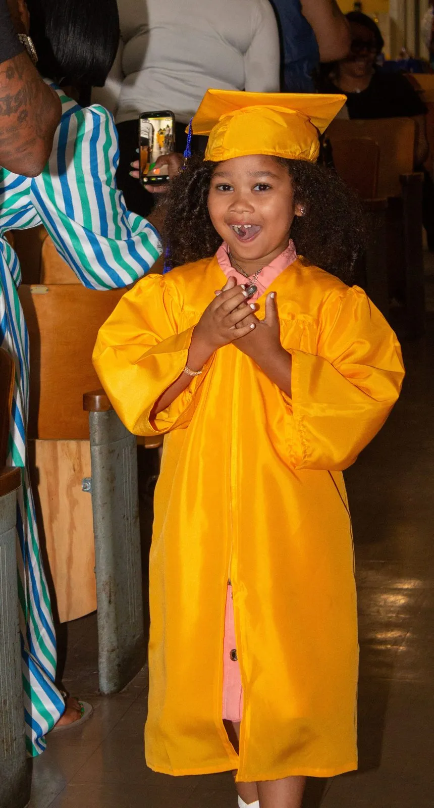 Young graduate in a yellow gown celebrating